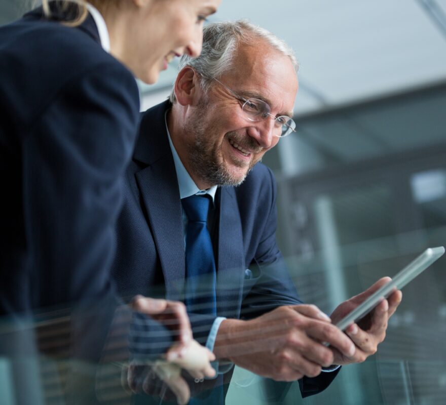 Businessman with colleague using digital tablet in office